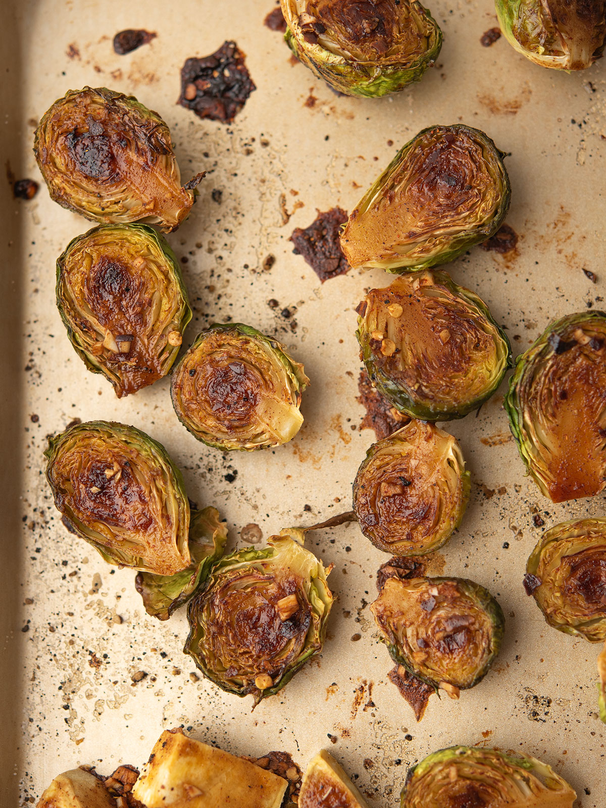Roasted brussels sprouts with sweet potatoes are glazed with balsamic and maple sauce.
