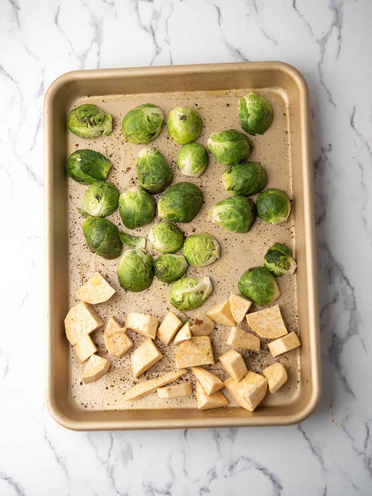 Roasted brussels sprouts and the sweet potatoes placed in the tray.