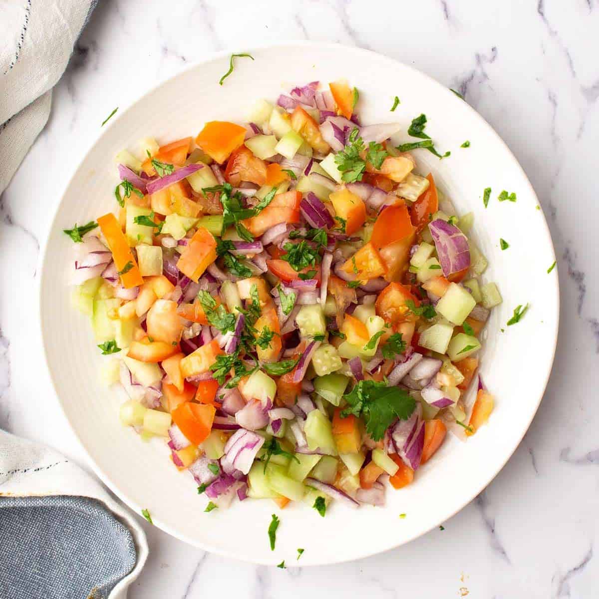 the Indian tomato salad garnished with cilantro is ready to eat