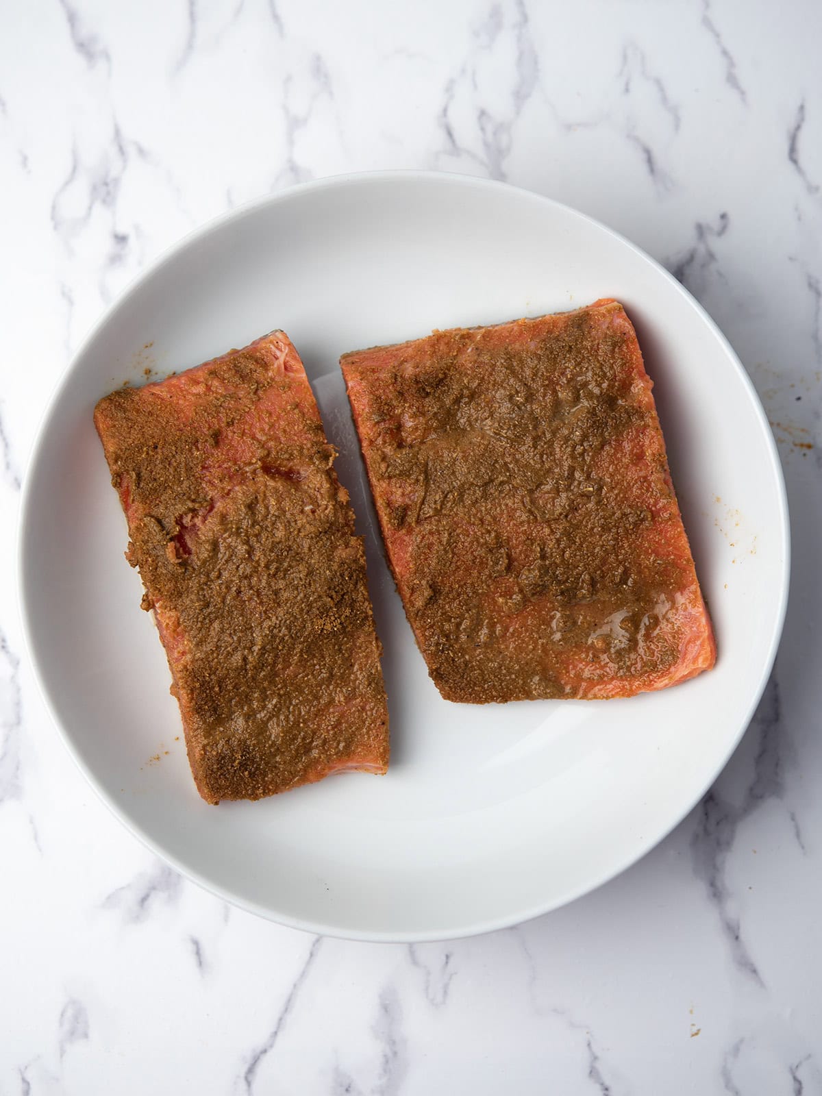 Rubbing seasoning onto salmon fillets