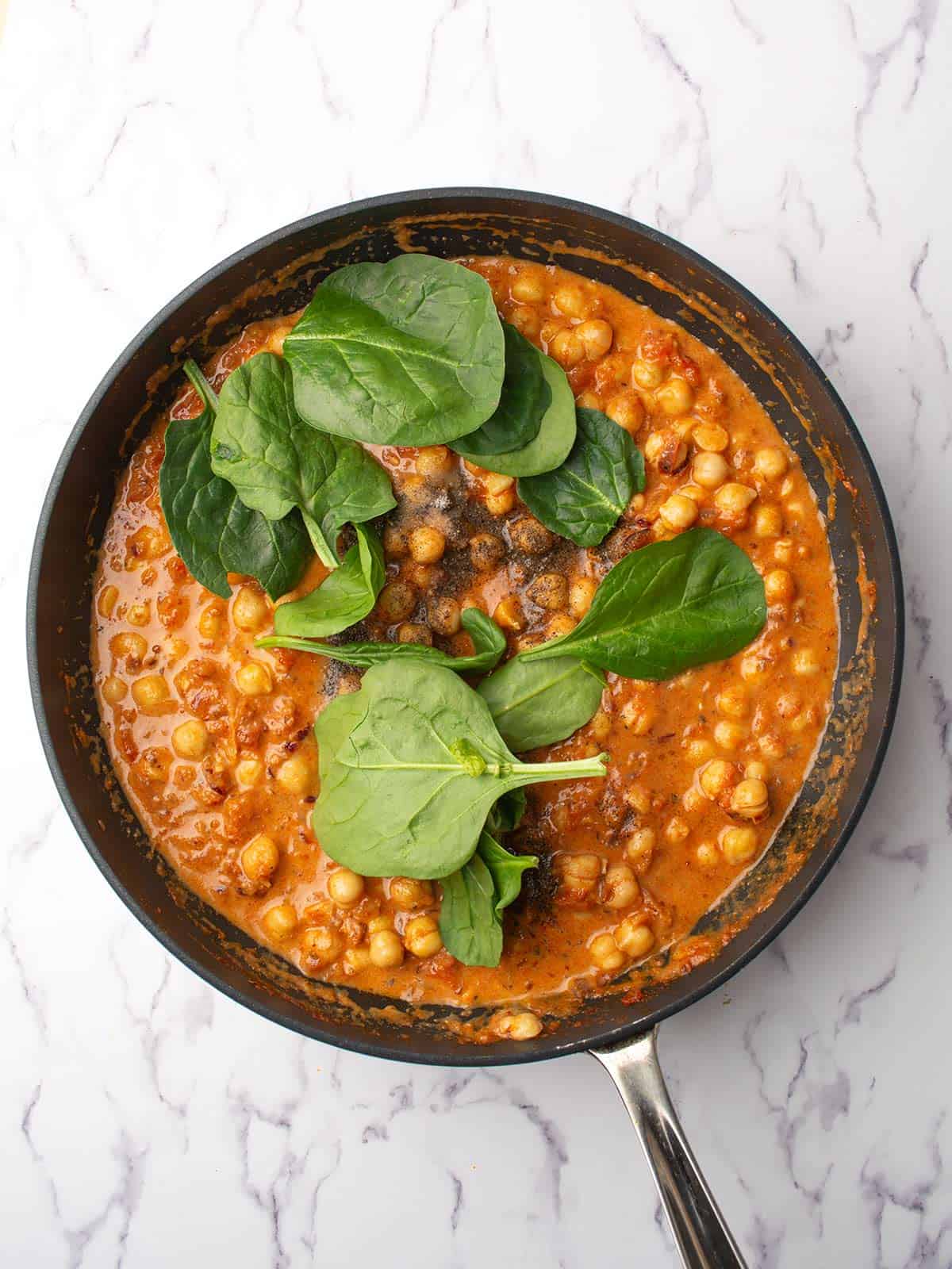 added chickpeas and spinach to the pan.