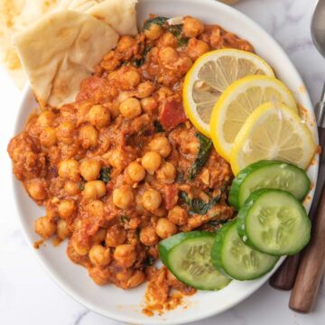 creamy harissa chickpeas with caramalized onion served with lemon, bread and veggies