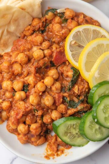 creamy harissa chickpeas with caramalized onion served with lemon, bread and veggies
