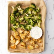 roasted broccoli and potatoes served with the sauce over weeknight dinner table