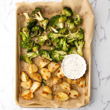 roasted broccoli and potatoes served with the sauce over weeknight dinner table
