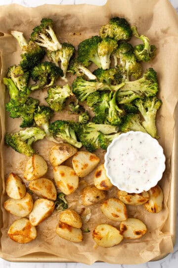 roasted broccoli and potatoes served with the sauce over weeknight dinner table