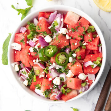watermelon jalapeno salad served with lemon wedges.