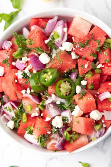 watermelon jalapeno salad served with lemon wedges.