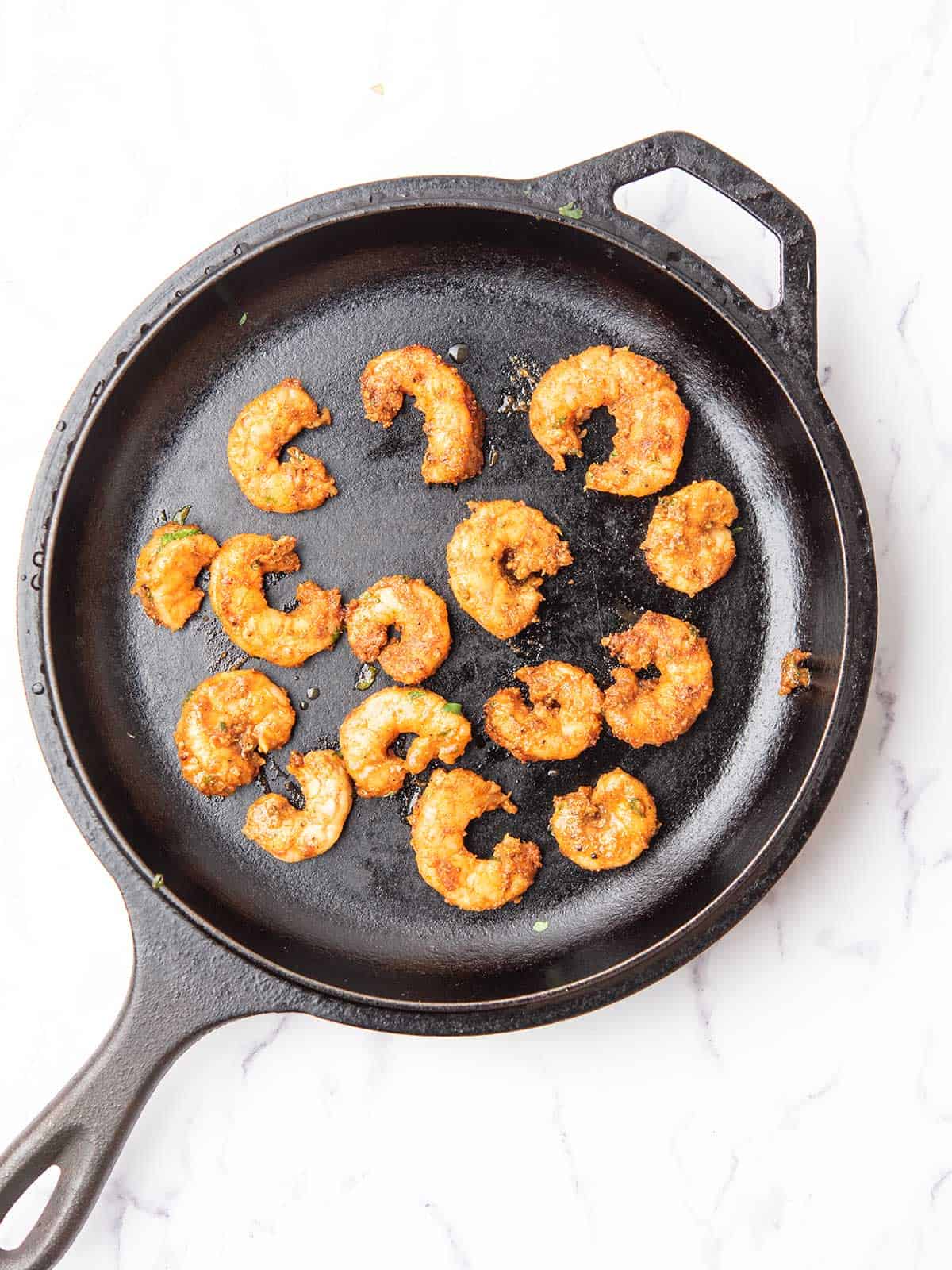 seasoned shrimp cooked over cast iron pan.
