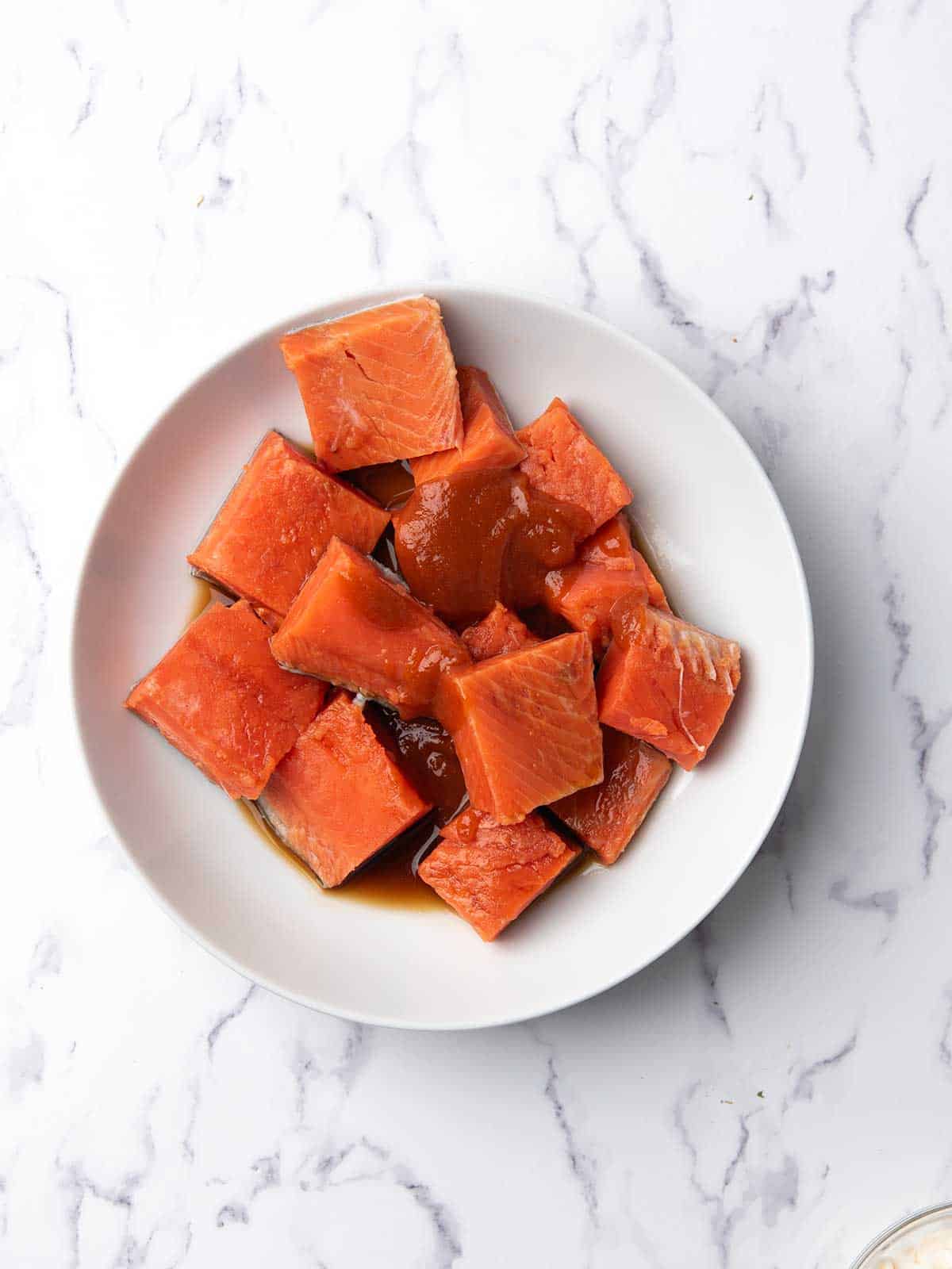 salmon cubes marinade in a mixing bowl.