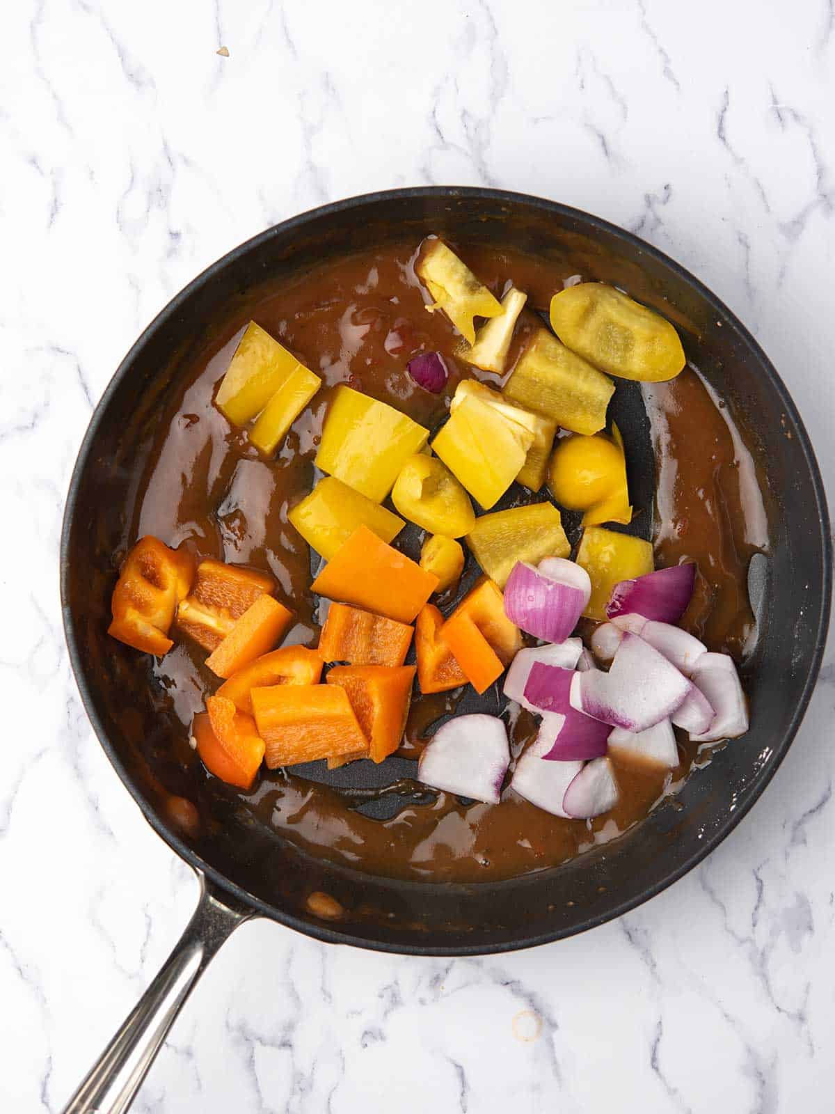 diced peppers and onion are added to the firecracker sauce.