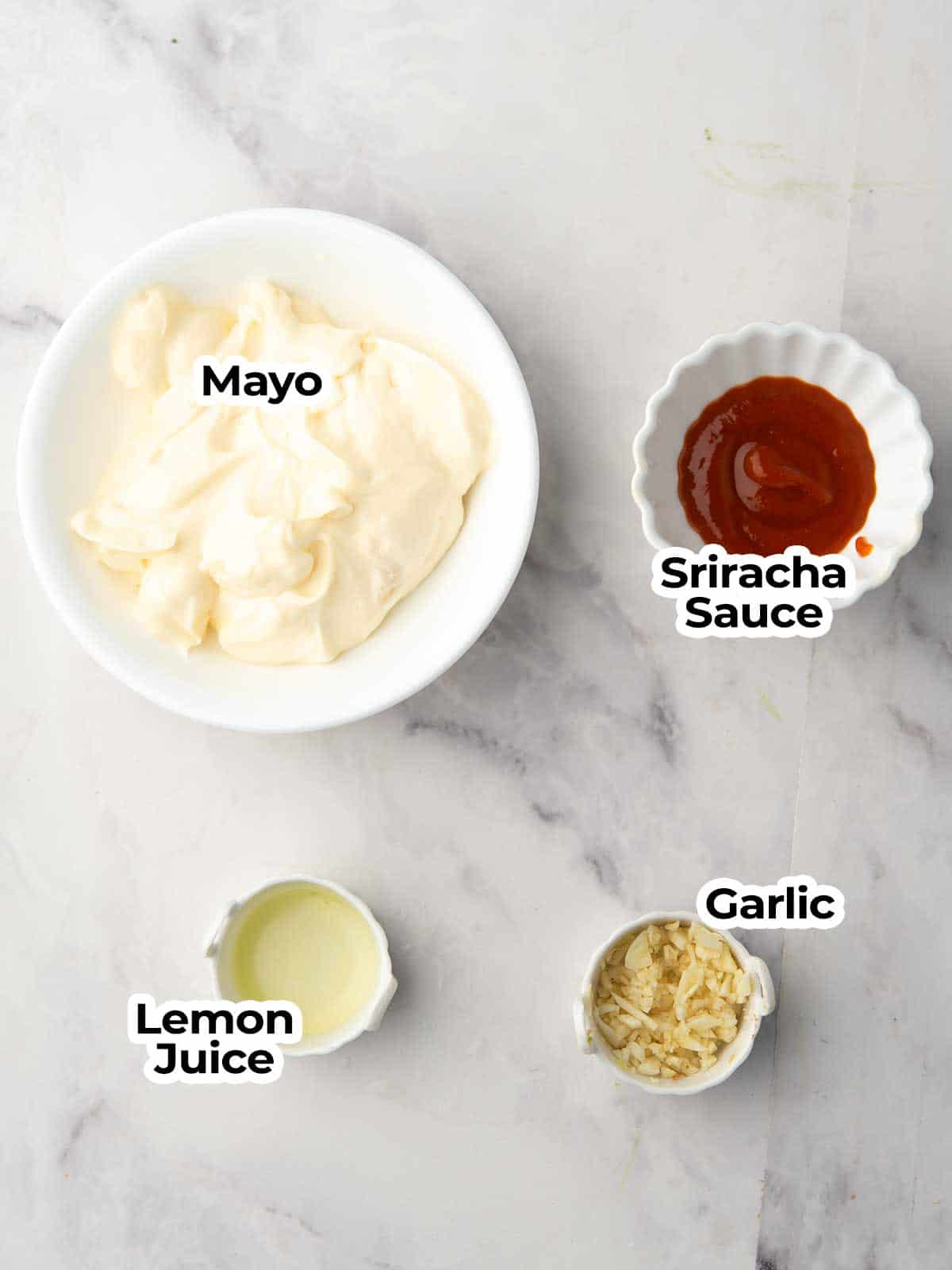 ingredients for the spicy garlic aioli are arranged in the kitche marble counter.