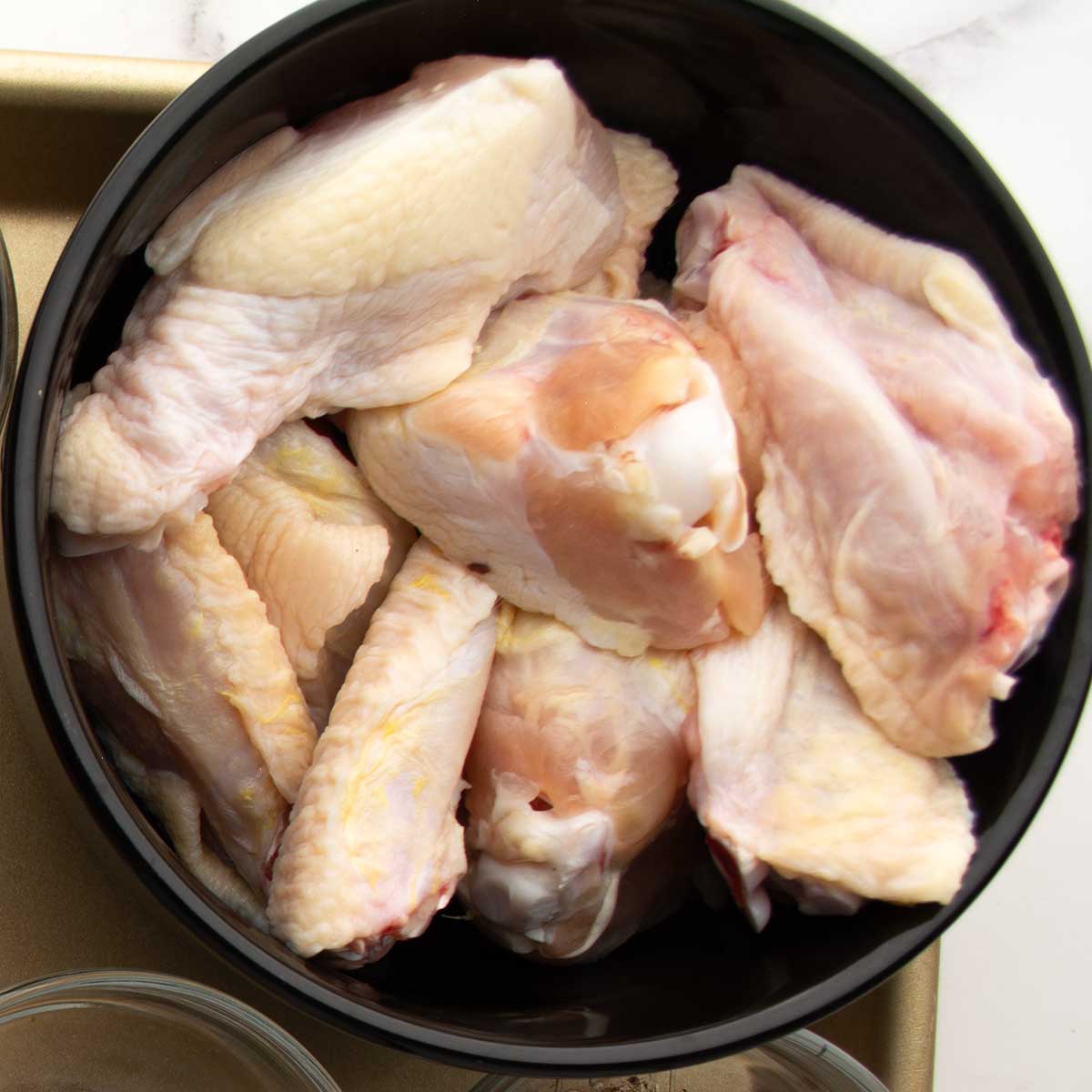 chicken wings are prepped and placed in a bowl.