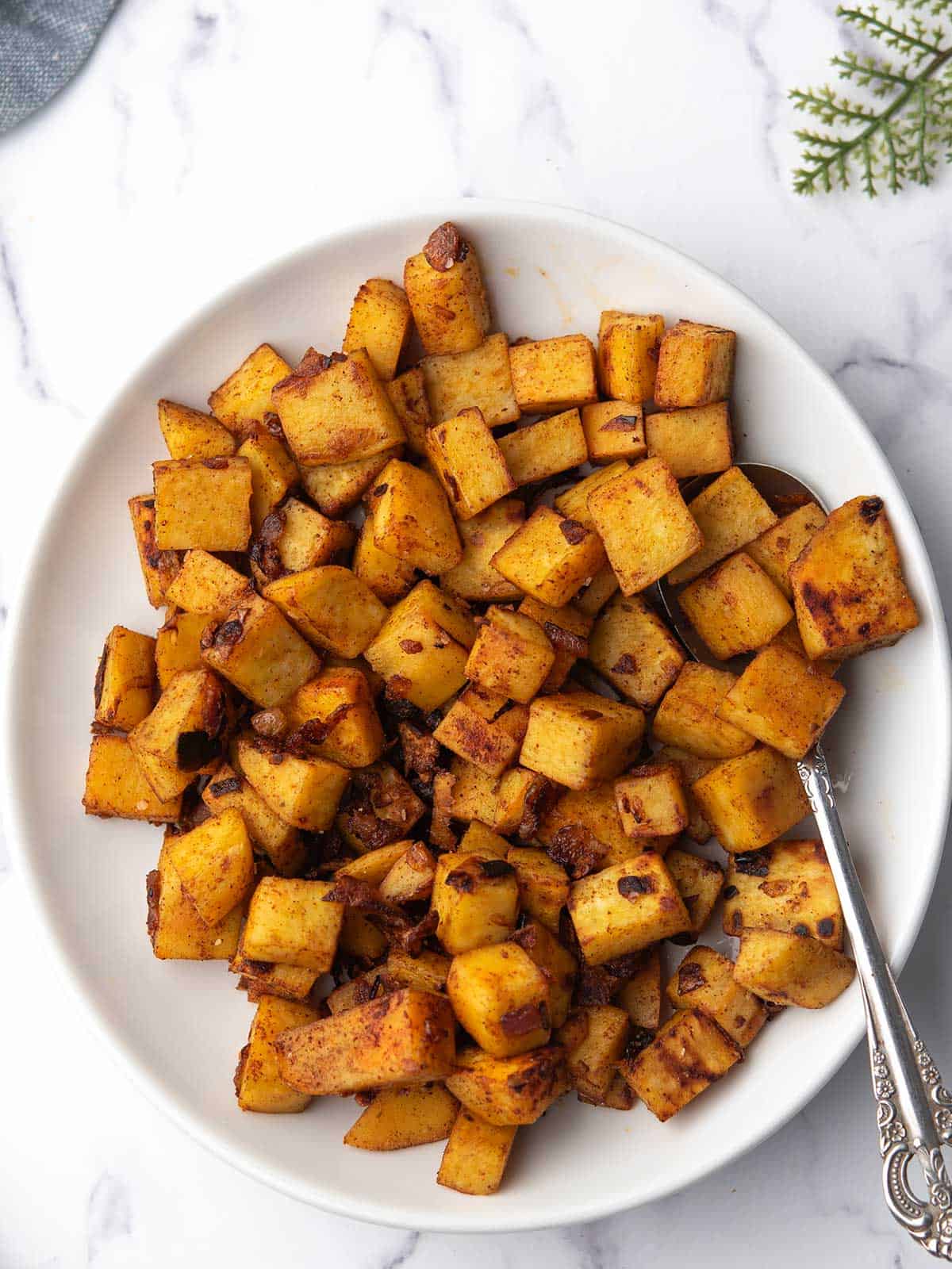 Sautéed sweet potatoes with browned edges, ready to serve.
