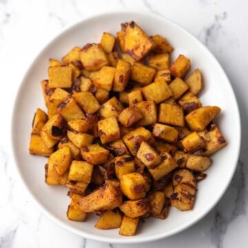 Sautéed sweet potatoes with browned edges, coated with smoked paprika, ready to serve as the side dish.