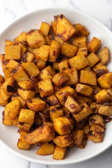 Sautéed sweet potatoes with browned edges, coated with smoked paprika, ready to serve as the side dish.