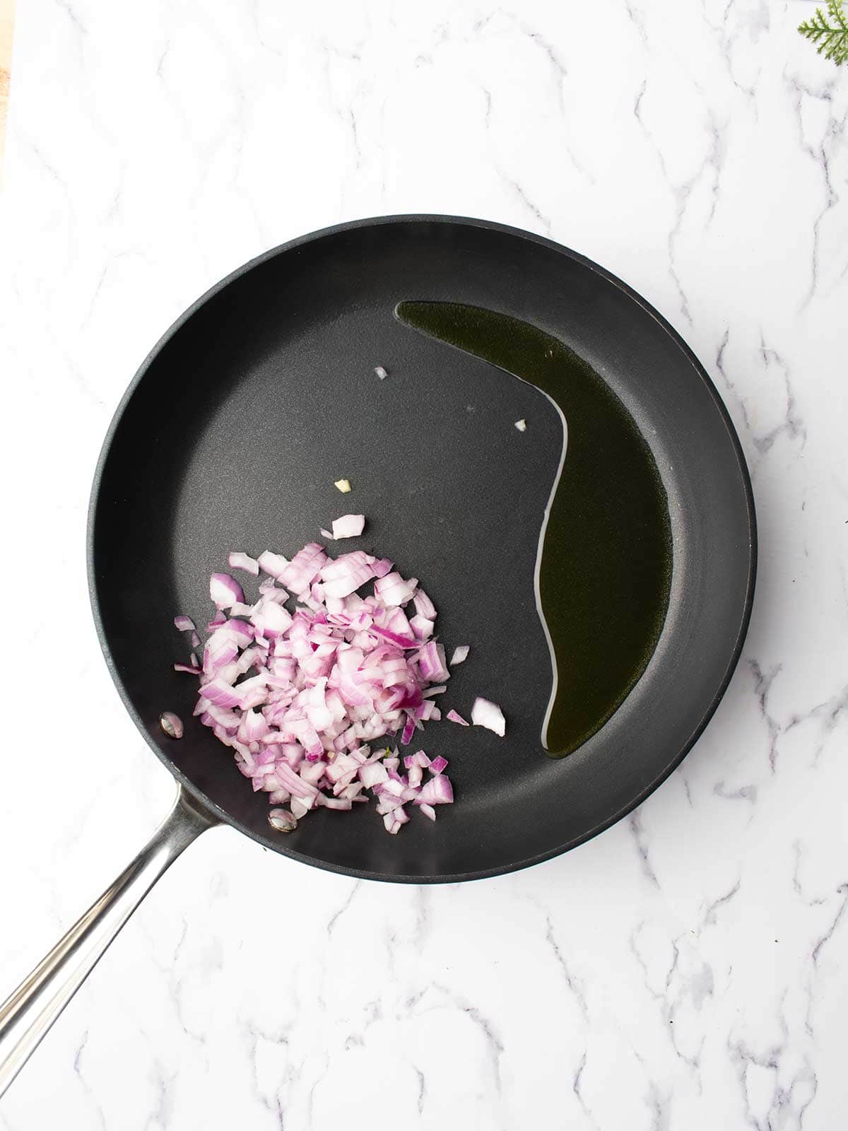 Diced red onion cooking in olive oil in a skillet