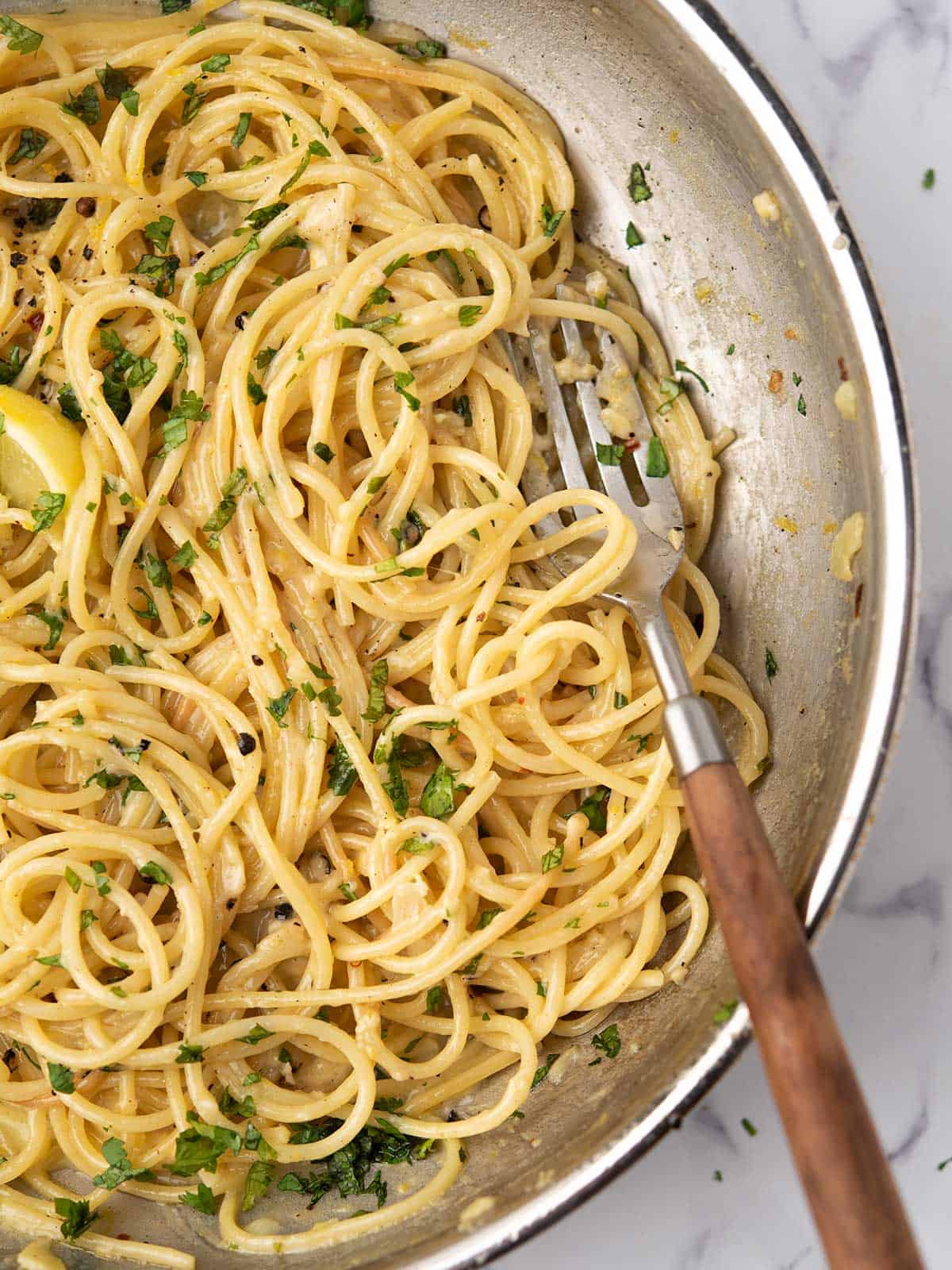 the glossy lemon pepper pasta in the pan, tossed with lemon zest and juice.