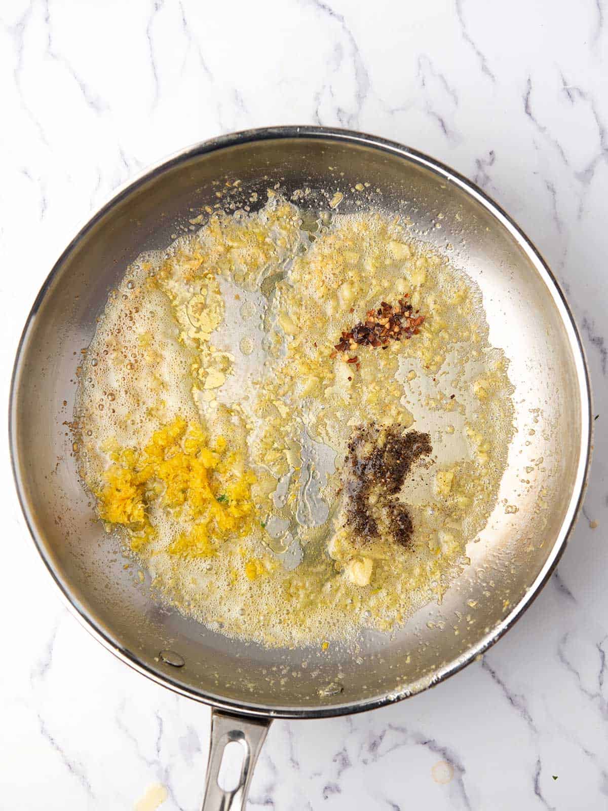 Adding lemon juice, zest, and spices for making lemon pepper pasta.